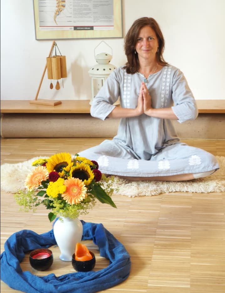 Nicole in Meditationshaltung mit Blumen